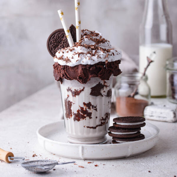 Sweet milkshake with chocolate cookies and whipped cream